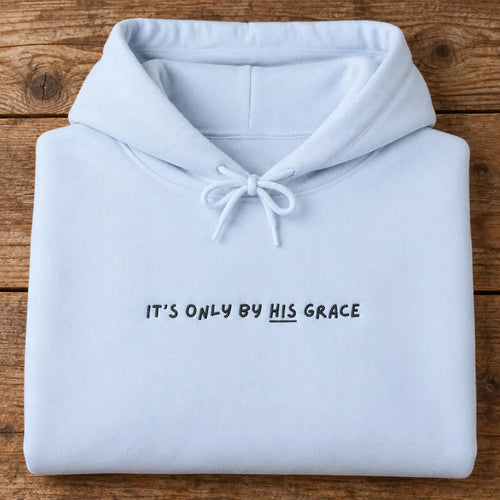 Folded light blue hoodie with black It's only by His grace chest lettering